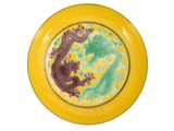 une assiette jaune ornée d'un dragon sur fond blanc