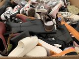 une boîte en carton remplie de chaussures et d'autres objets