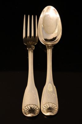 deux cuillères et une fourchette posées sur une table noire