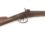 un vieux fusil exposé sur une surface blanche