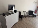 a desk with a monitor and a chair in a room