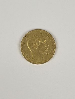 gros plan d'une pièce d'or sur une surface blanche