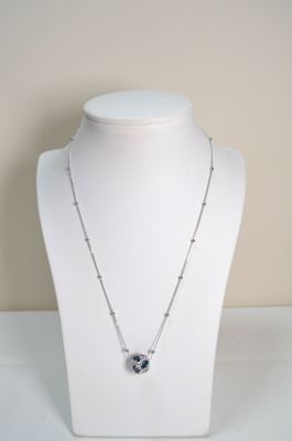 silver necklace with black and white heart pendant on a white mannequin