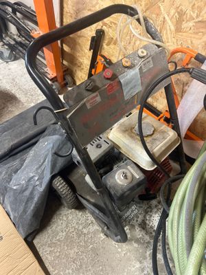 une photo d'un homme utilisant un nettoyeur haute pression dans un garage