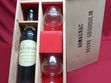 une bouteille de vin et un verre dans un coffret en bois