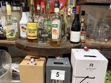 de nombreuses bouteilles d'alcool posées sur un comptoir à côté de cartons