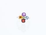 un gros plan d'une bague ornée de trois pierres de couleurs différentes