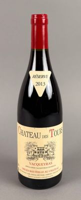une bouteille de vin rouge posée sur une surface grise, avec une étiquette dessus