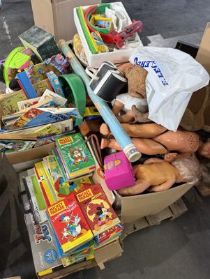 un tas de jouets dans une boîte en carton posée par terre