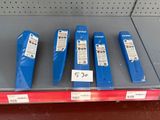 cinq boîtes en plastique bleues posées sur une étagère dans un magasin