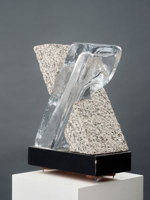 a sculpture of a rock and a piece of glass on top of a white pedestal