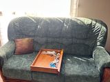 a green couch with a tray on it in a living room