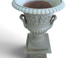 a white vase that is sitting on top of a pedestal