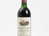a bottle of red wine sitting on top of a white table