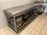 une grande table en inox sur laquelle sont posés tout un tas de plats