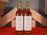 two bottles of wine sitting next to each other on a table