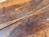 a close up of a wooden table with peeling paint on it