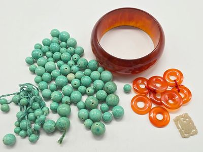 un bol rempli de perles, un autre bol rempli de perles et un bracelet posés sur une table