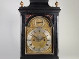 une horloge noire et dorée dont le cadran est orné de chiffres romains