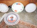 four plates sitting on the floor next to a dresser