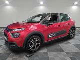 Une voiture rouge est garée dans une pièce dont le sol est en damier.