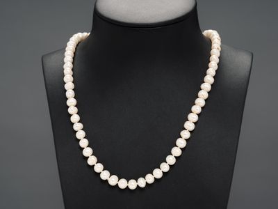 un collier de perles blanches autour du cou d'un mannequin