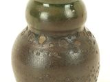 a brown vase with holes in it on a white surface