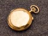 une montre de poche en or contenant une clé