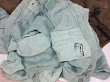 a pile of clothes that is sitting on a bed