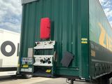 un semi-remorque vert garé sur le bord de la route