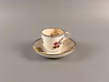 une petite tasse posée sur une soucoupe
