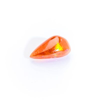 a close up of an orange quartz stone on a white surface