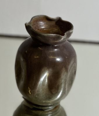 un petit vase posé sur une table en verre