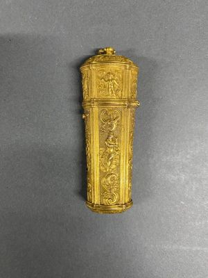 an antique gold plated clock on a gray surface with a black background