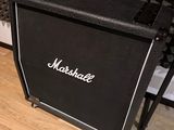 a black amp sitting on a wooden floor in front of a wall