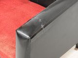 an image of a black leather couch with red cushions