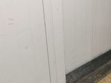 a bathroom with a toilet and a trash can on the floor