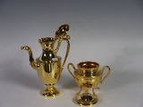 two gold vases sitting next to each other on a table