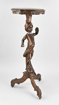 an antique bronze table with a lady holding a bird on it ' s head