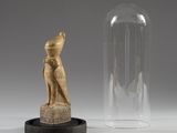 an egyptian figurine and a glass dome on a table