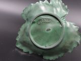 a close up of a green vase on a table
