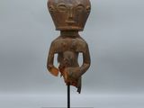 une sculpture en bois représentant un homme tenant un oiseau sur un socle