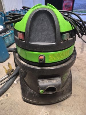 une photo d'un aspirateur vert et noir posé sur une table