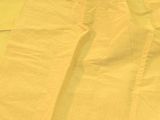 a close up of a pair of yellow pants on a bed