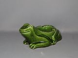 une petite figurine de grenouille verte posée sur une table