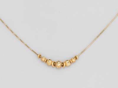 un collier plaqué or composé de cinq perles montées sur une chaîne