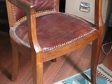 a brown leather chair sitting in front of a computer desk