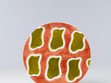 une assiette orange et verte posée sur une table blanche
