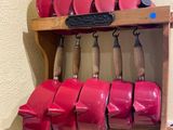 a shelf with a bunch of red pots and pans on it