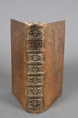 an old book with a brown cover sitting on top of a table